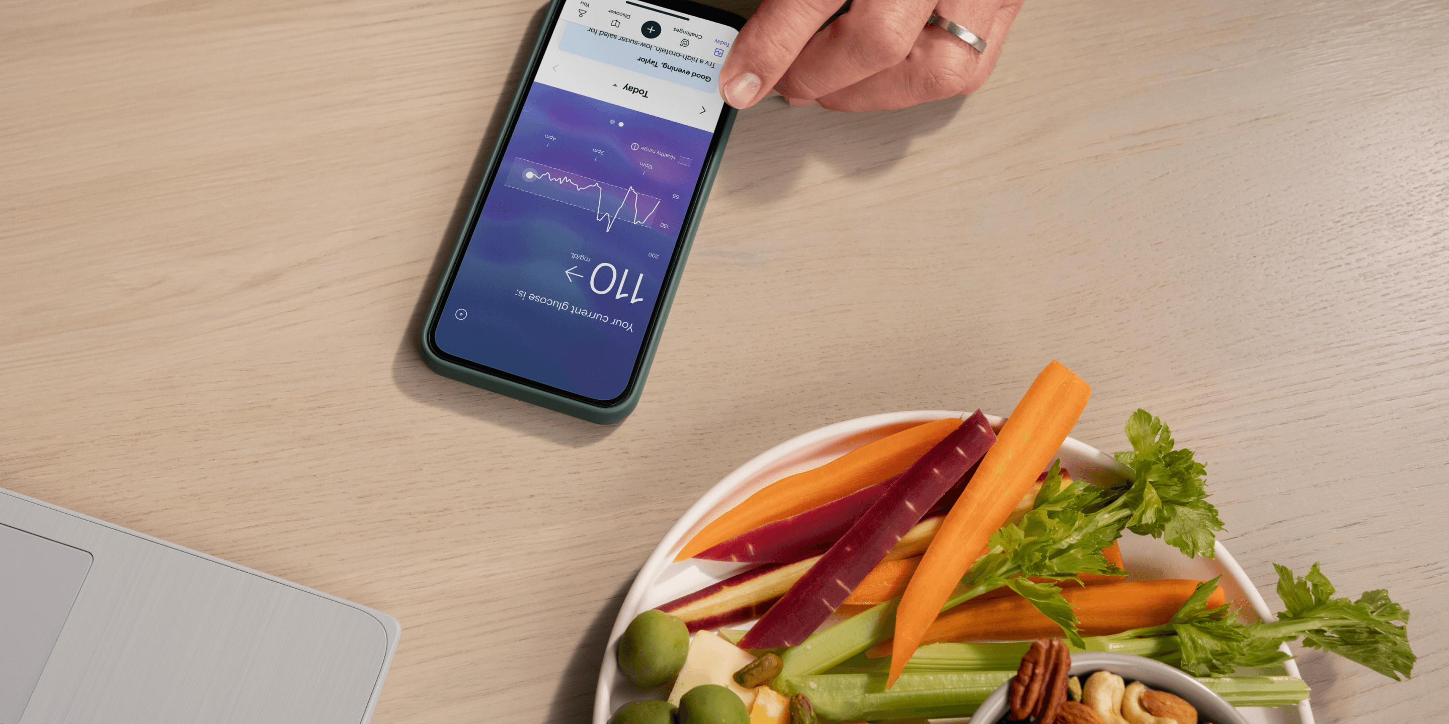 Plate of plant-based snacks next to smartphone with Lingo app. 