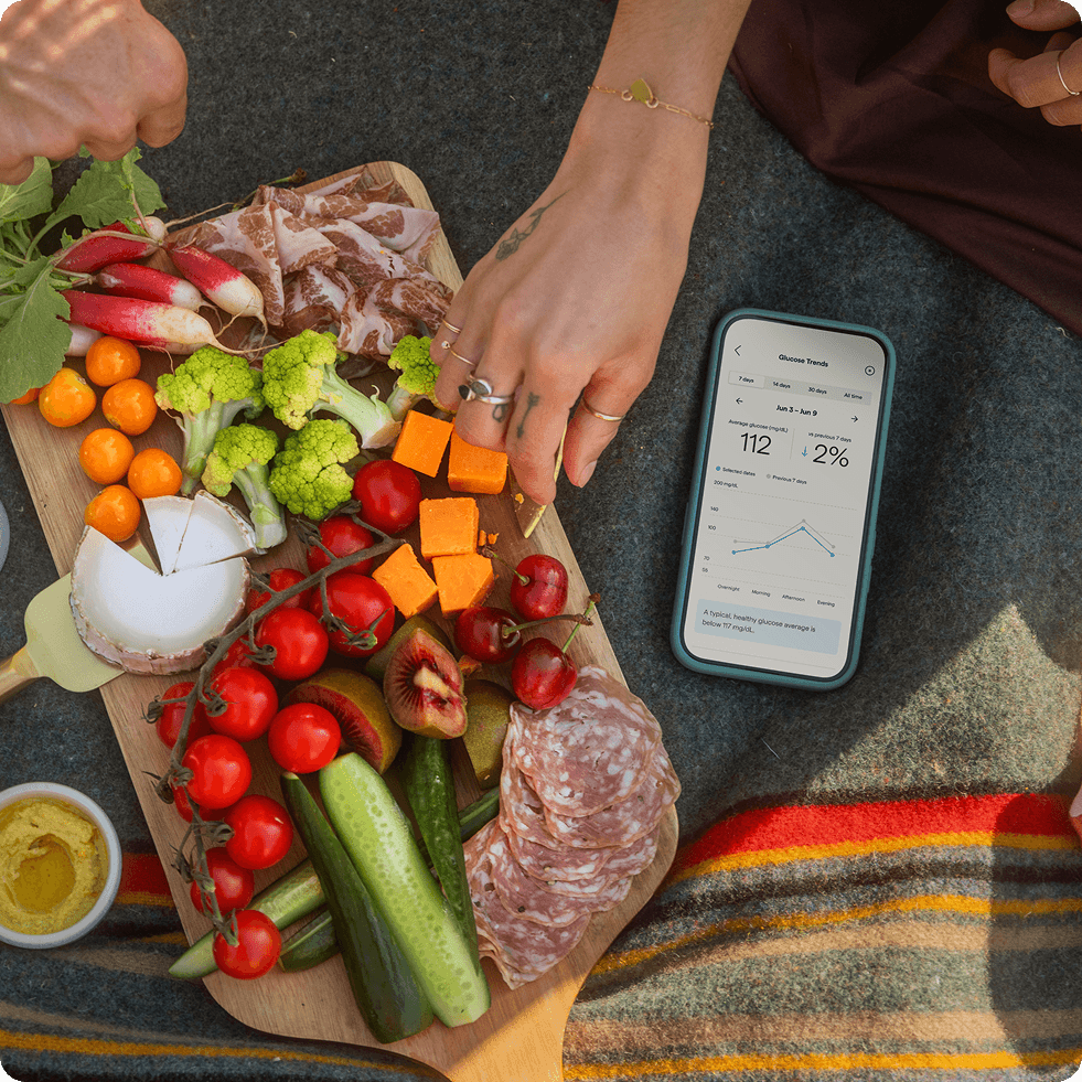 Charcuterie board with nutritious foods, with a phone displaying the Lingo app nearby