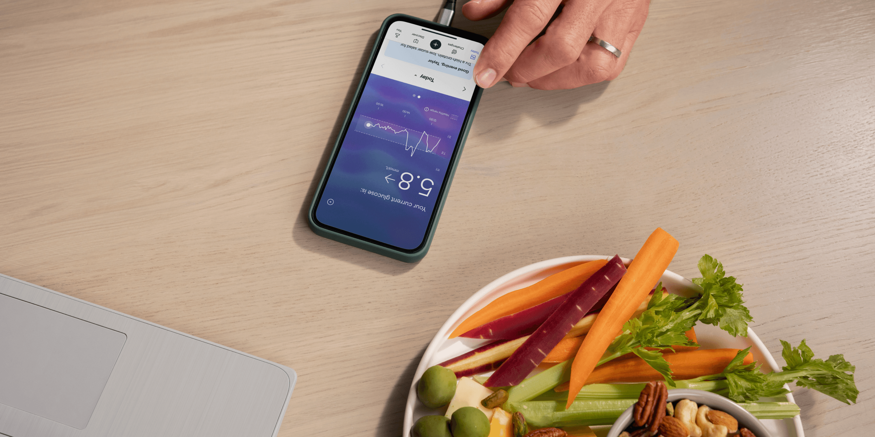 Plate of plant-based snacks next to smartphone with Lingo app. 
