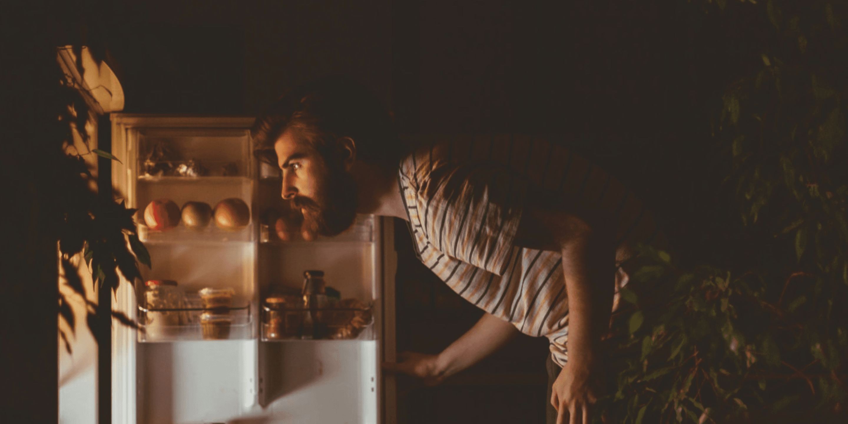 Man looking into fridge at night. 