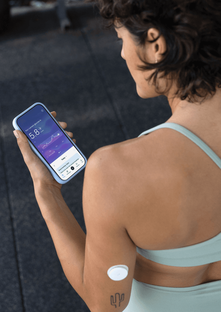 A woman in workout clothing looking at the Lingo app on her phone