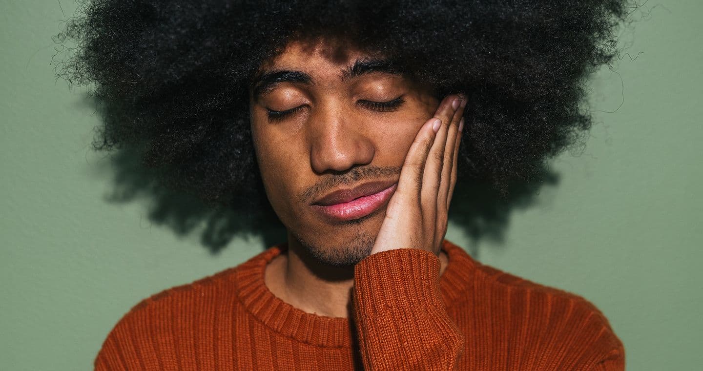 Person looking fatigued holding her forehead