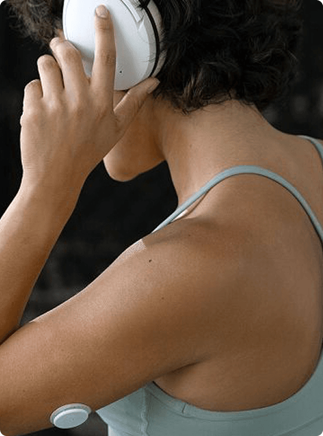 A woman in work out clothing wearing a biosensor