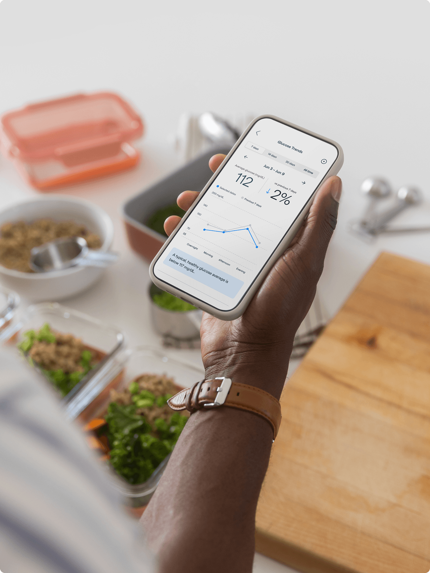 A person checking gluecose trends on Lingo while meal planning in their kitchen.