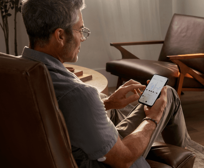 Man sitting looking at the Lingo app on his phone.