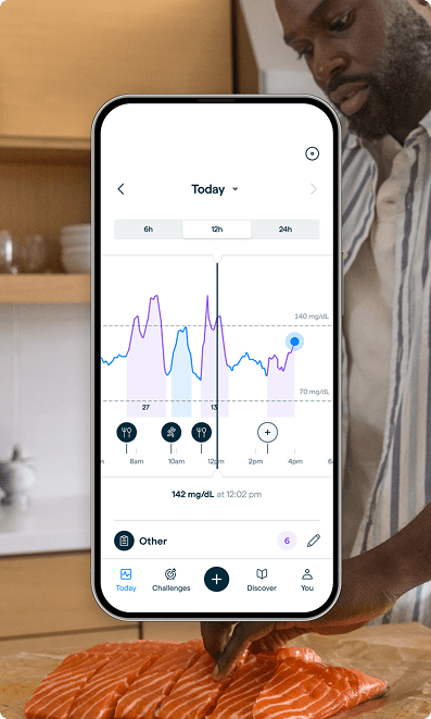 A man in a kitchen with a photo of a phone with the lingo app overlayed.