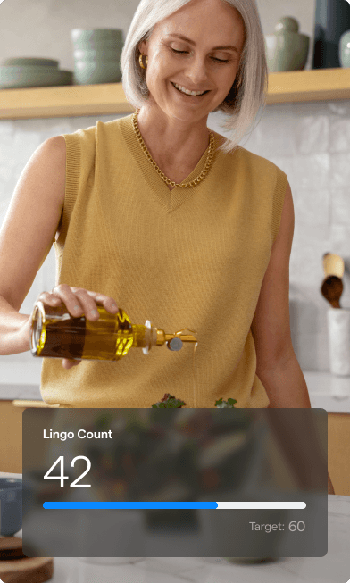 A photo of a woman smiling while pouring olive oil over her salad with a Lingo Count chart overlayed.