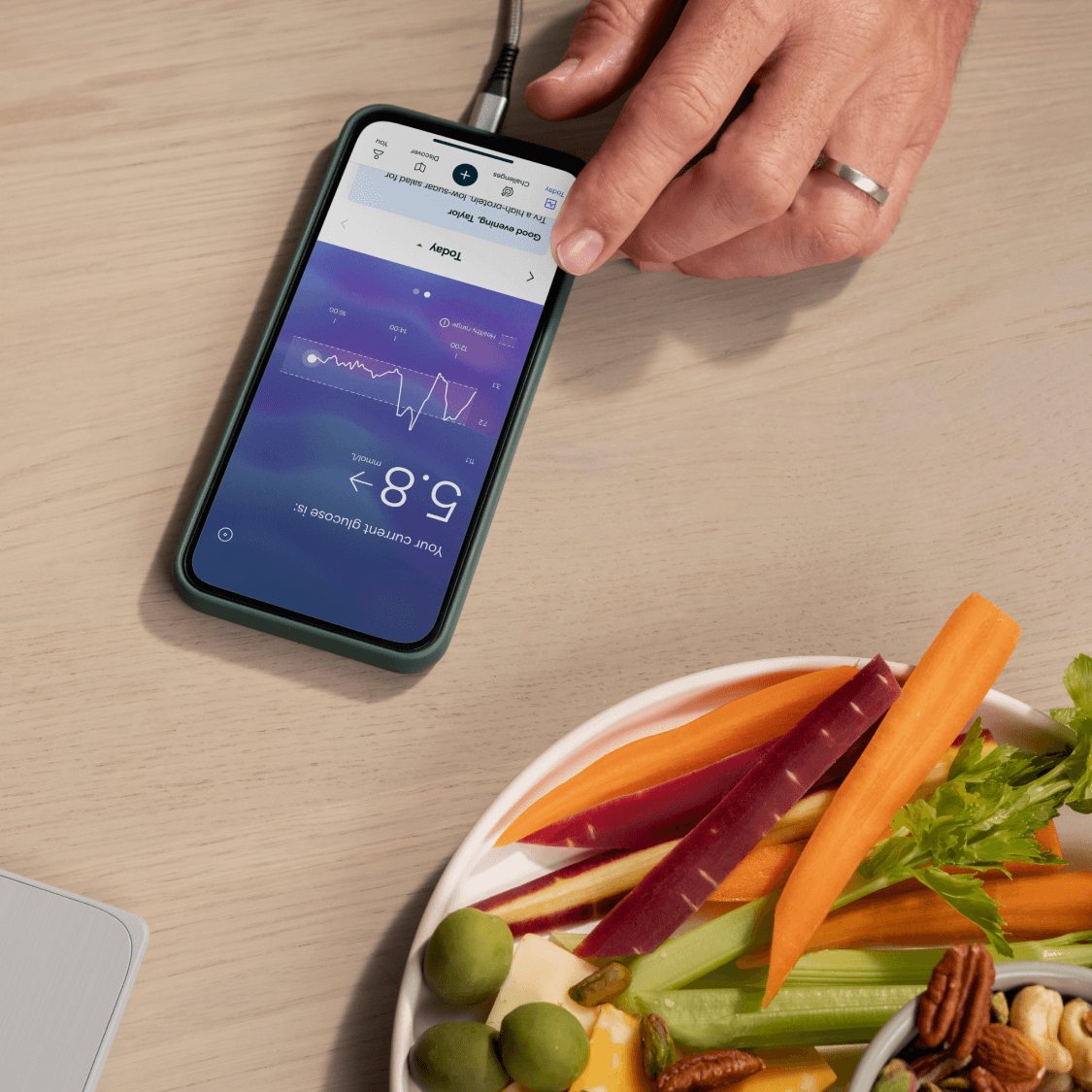 Plate of plant-based snacks next to smartphone with Lingo app.