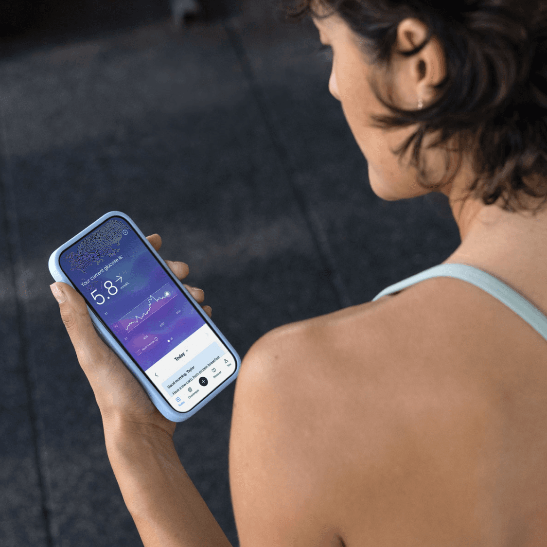 Woman in sportswear wearing a CGM and looking at the Lingo app