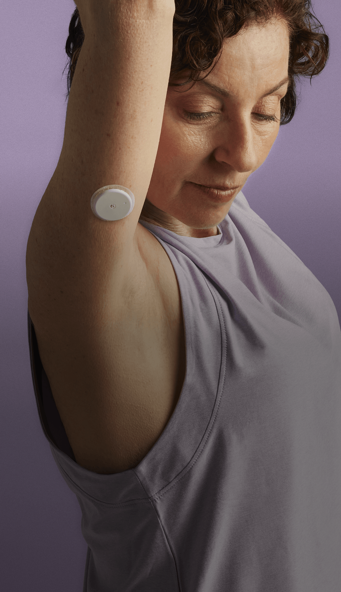Woman wearing biosensor with arms raised
