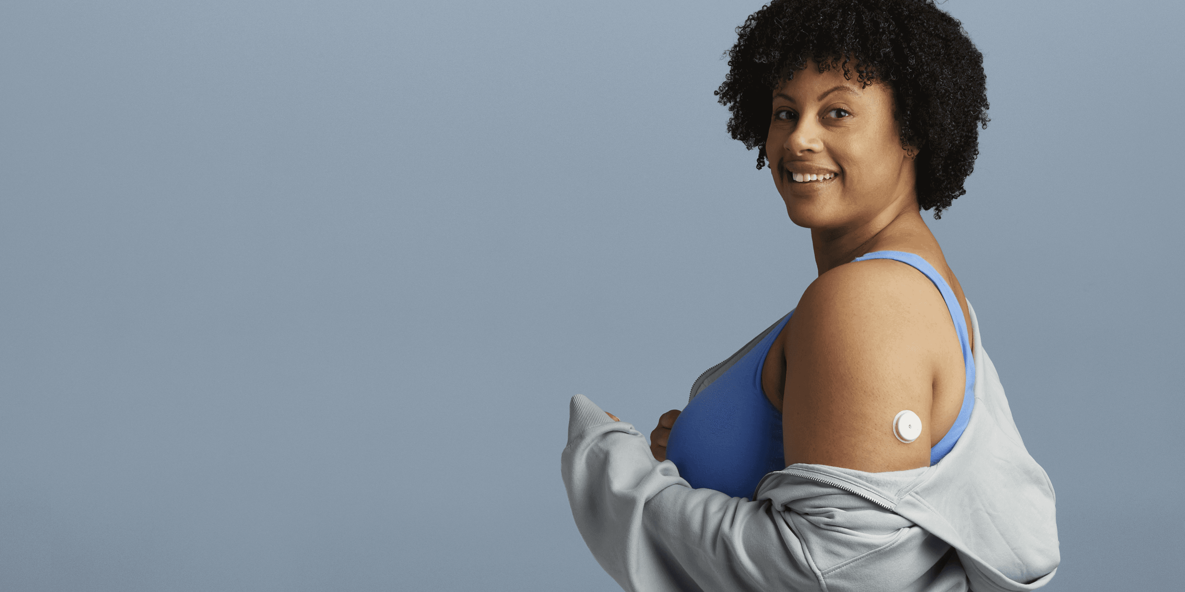 A woman wearing a Lingo Continuous Glucose Monitor
