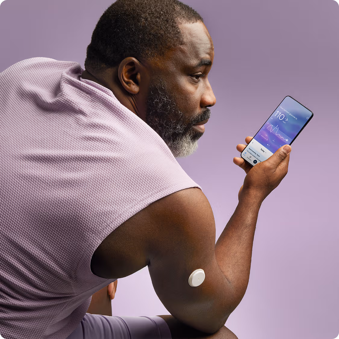 A man in a sleeveless shirt wearing a Lingo biosensor while looking at the Lingo app.