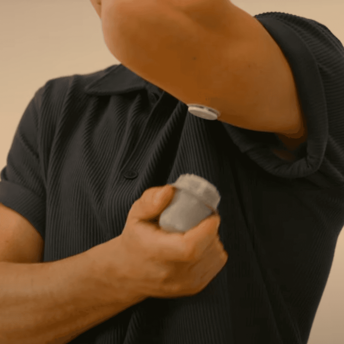 Person applies CGM to upper arm.
