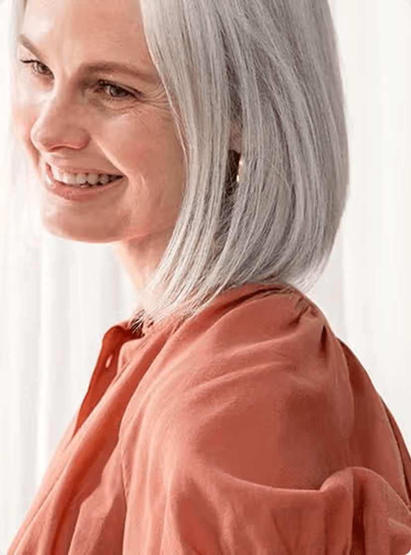 A woman wearing an orange shirt smiling
