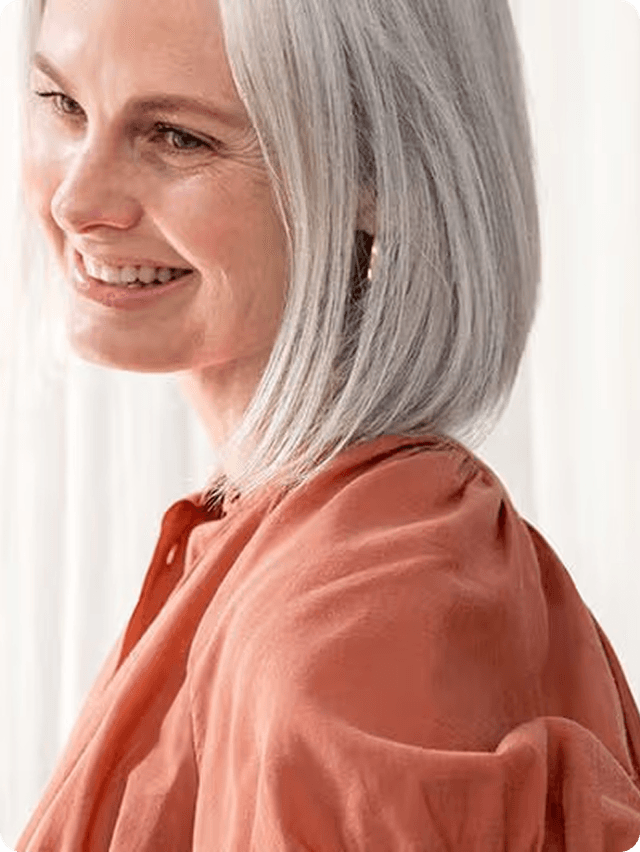 A woman wearing an orange shirt smiling