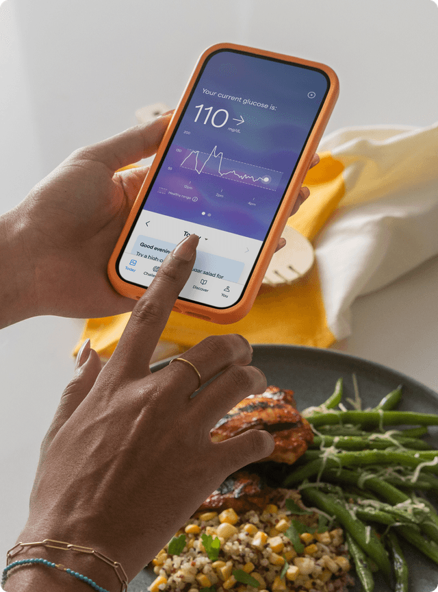 A person looking at phone with data about the plate of food they are about to have.
