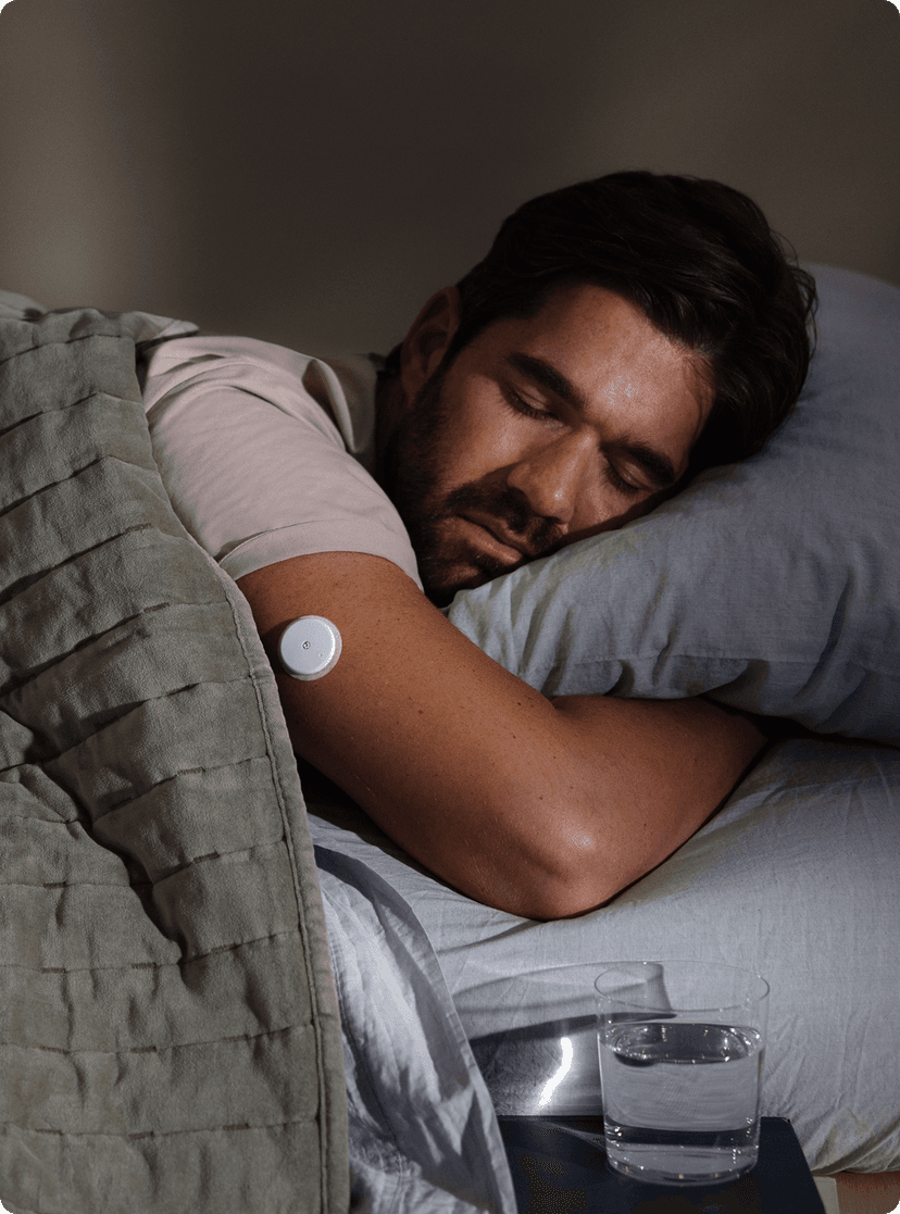 A man in bed sleeping soundly on his belly.