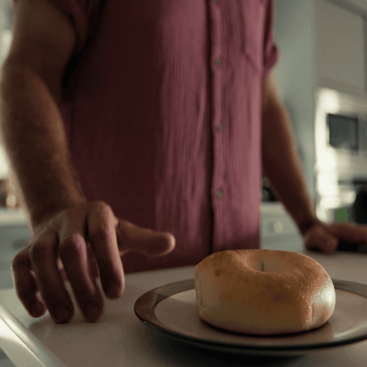 Ben is reaching for a bagel.