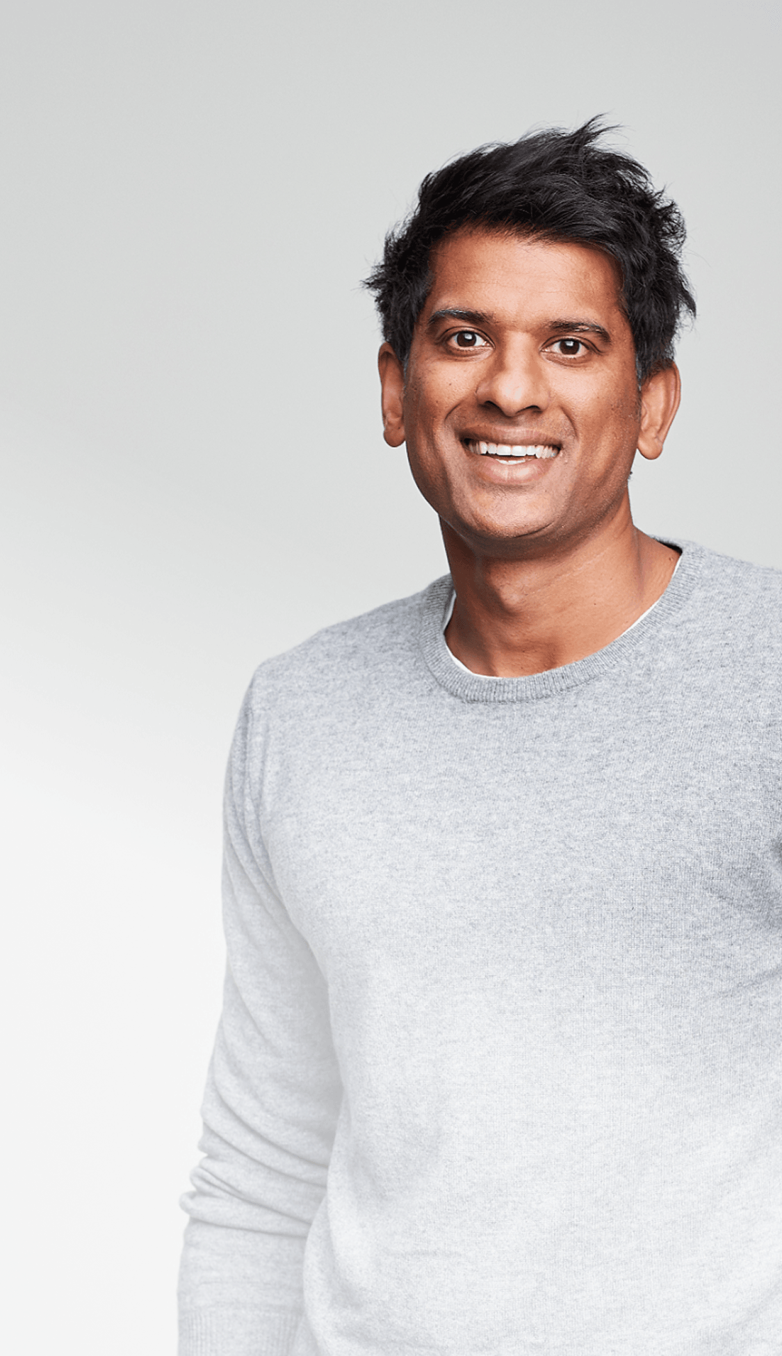 Dr. Chatterjee smiling wearing a gray sweater