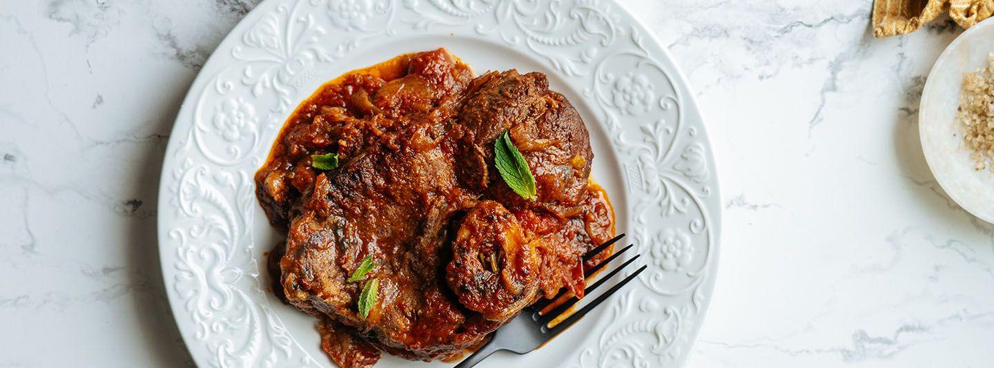 Plate of saucy meat and vegetables