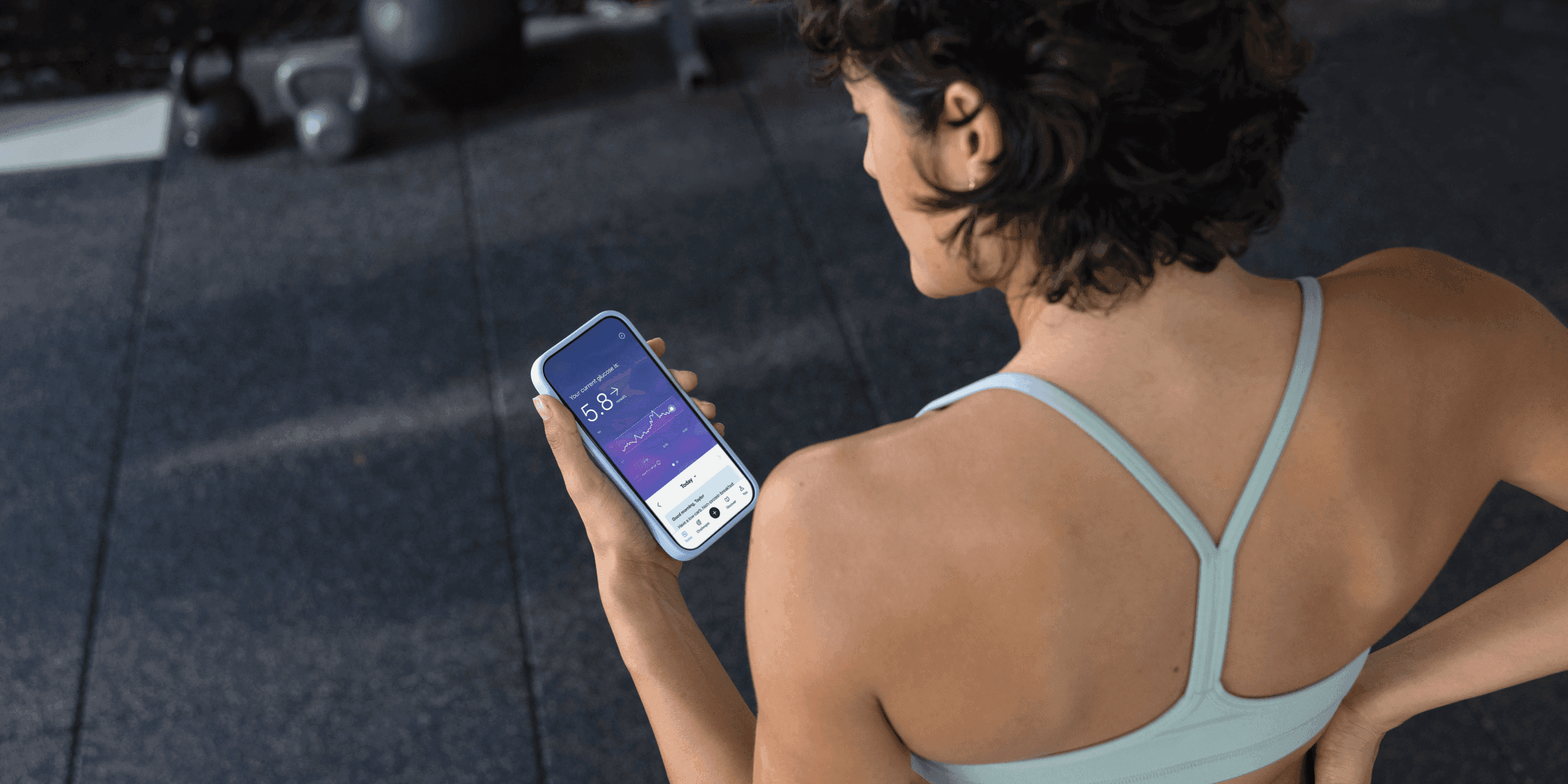 Woman in sportswear wearing a CGM and looking at the Lingo app