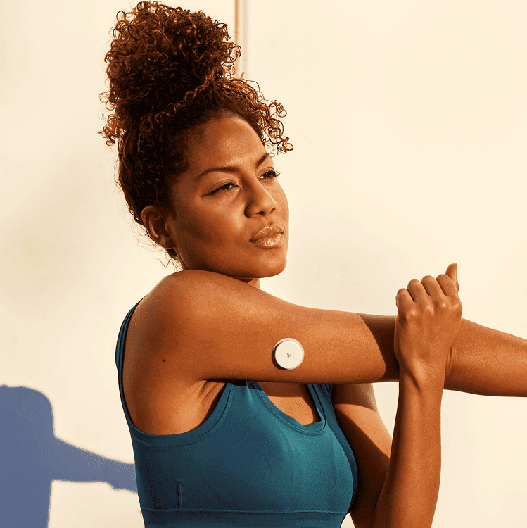 Women stretching wearing a CGM