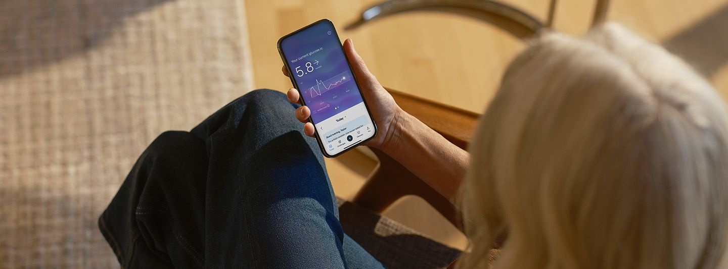 Person looking at glucose data on smartphone