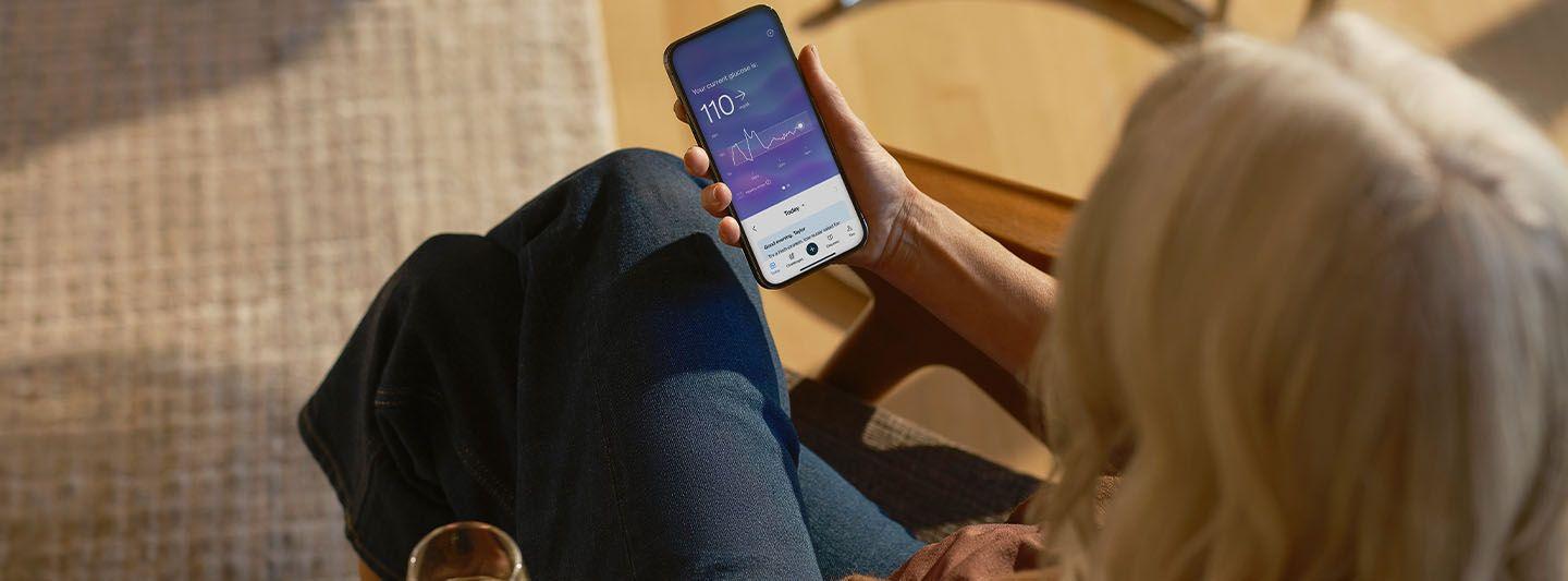 Person looking at glucose data on smartphone