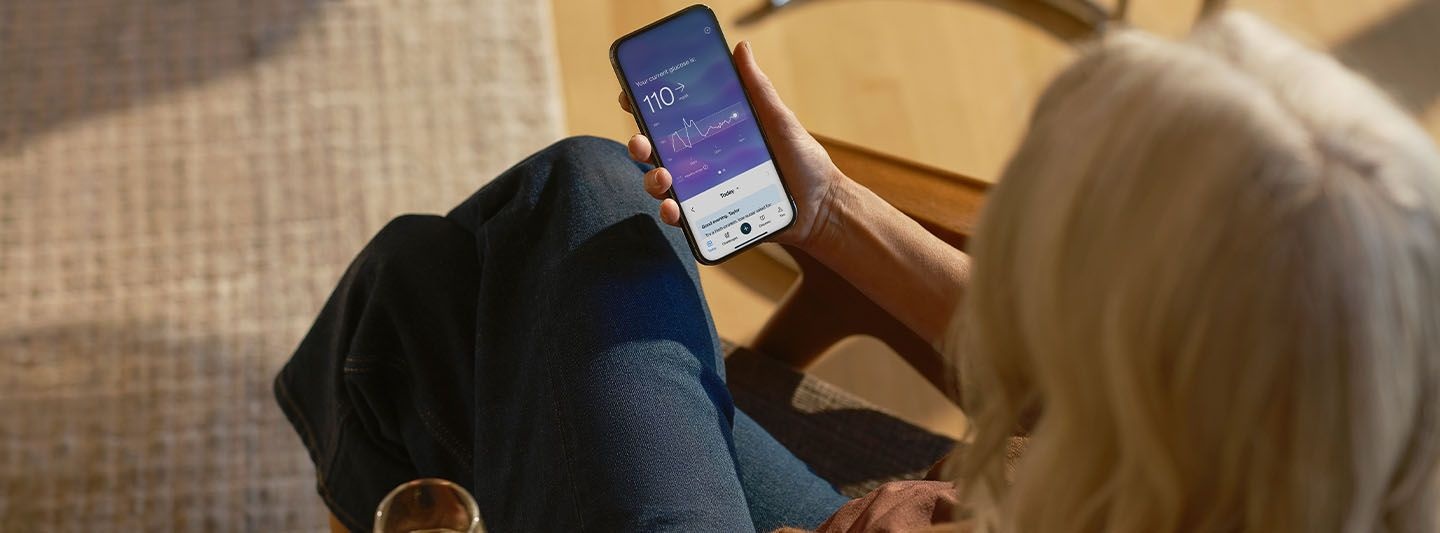 Person looking at glucose data on smartphone