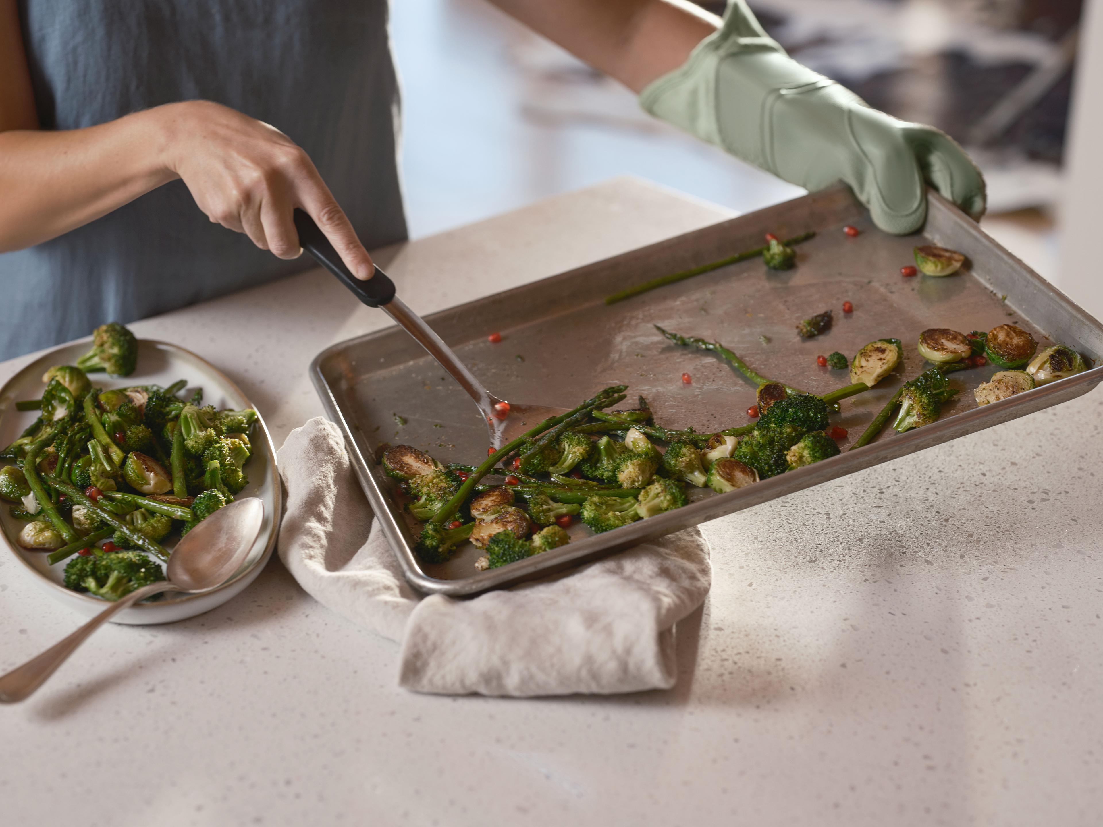 Tray of roasted green vegetables and pomegranate seeds