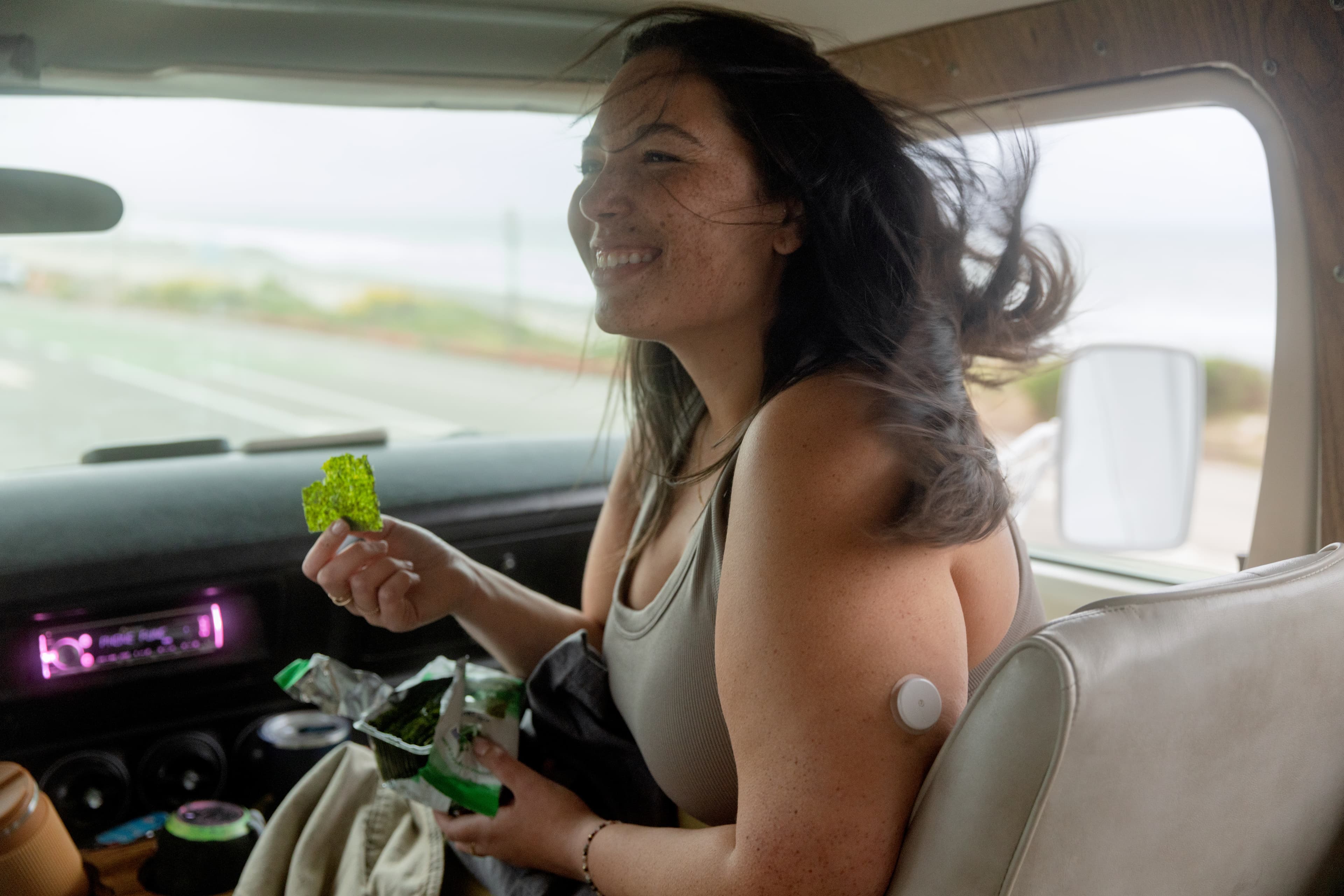 Woman in a car eating a seaweed snack.