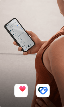 A person in a terracotta colored workout shirt checks her phone