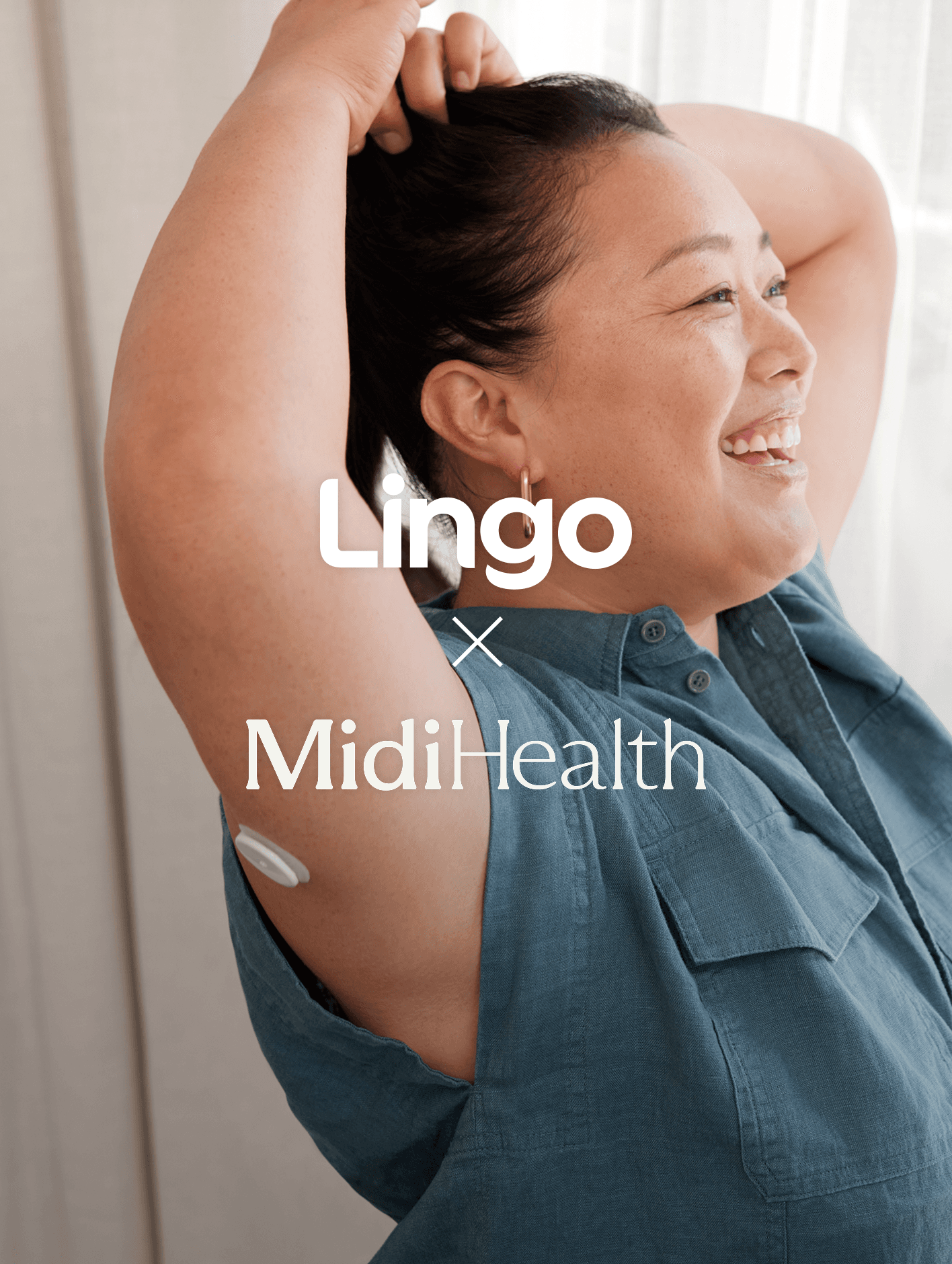 A smiling woman in a blue shirt with her arms over her head.