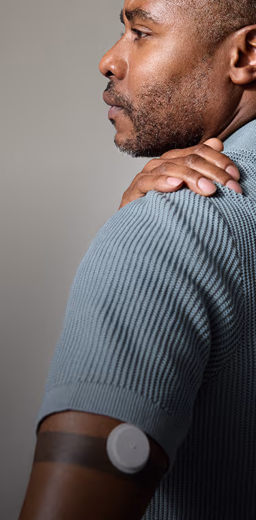 A man with his back turned wearing a Lingo sensor while looking to his left.