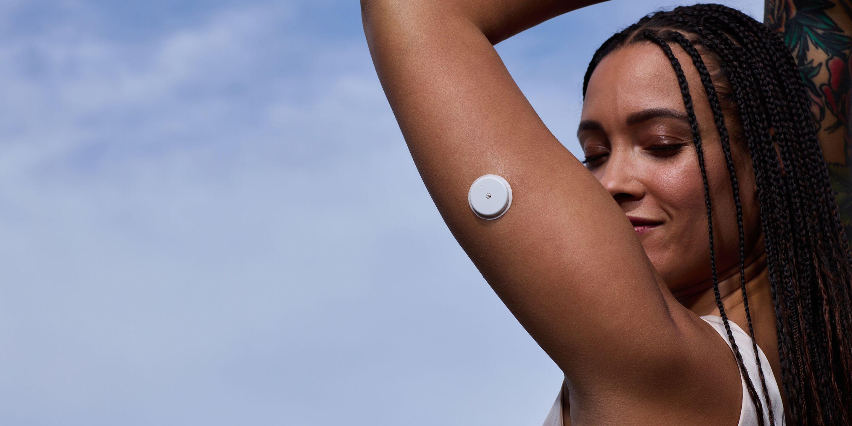 A woman wearing a Lingo Continuous Glucose Monitor