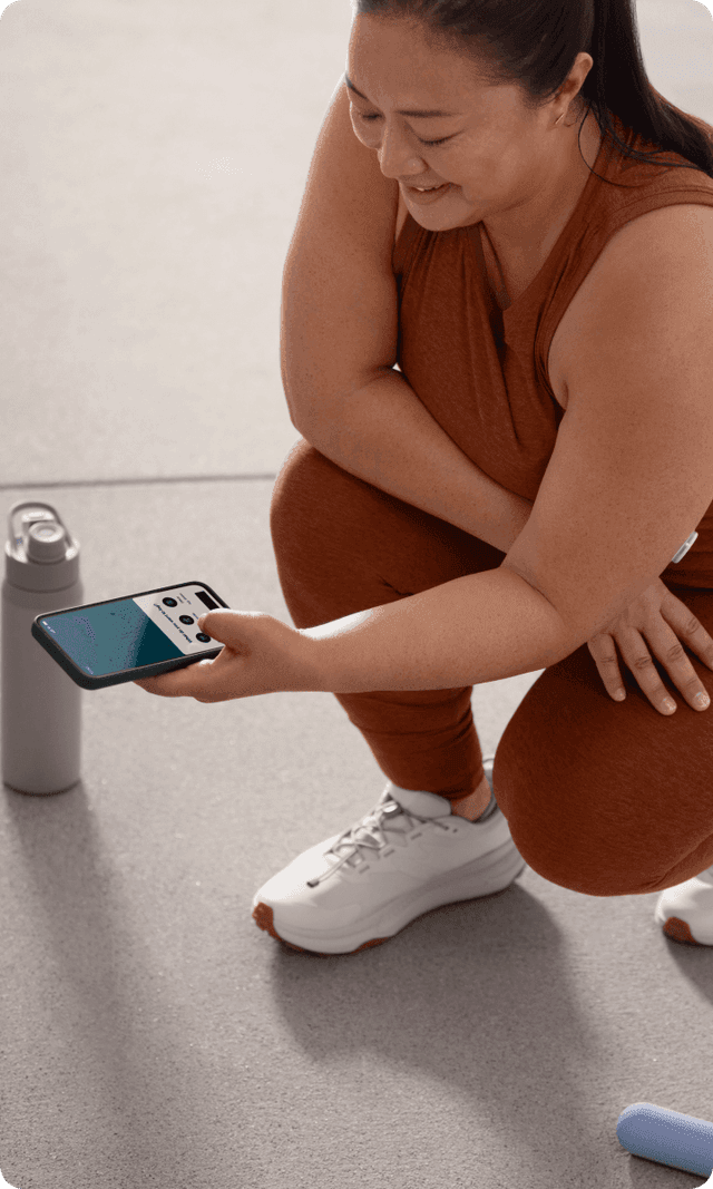 A person checking the Lingo app between sets of a workout