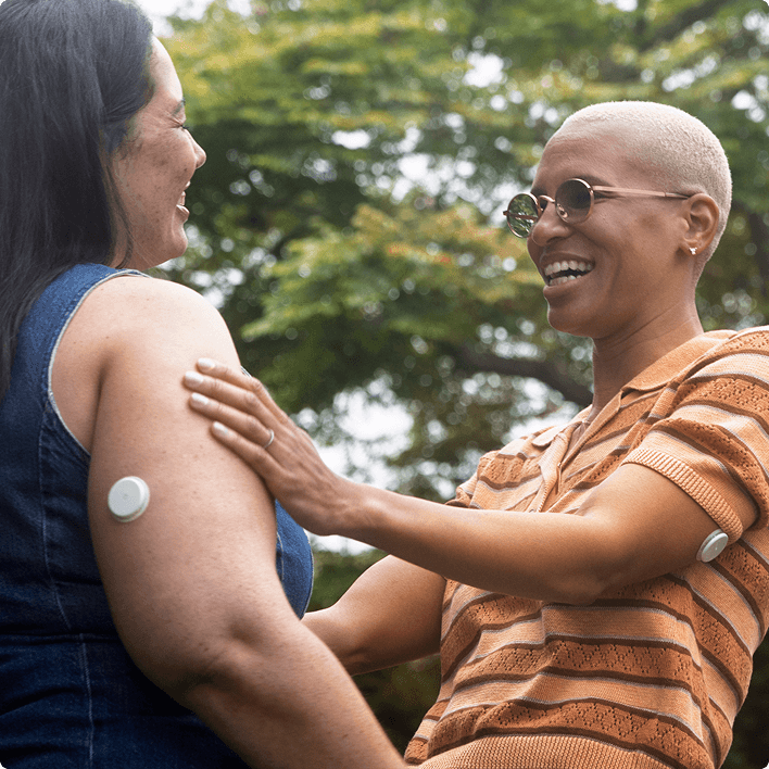 Two women smiling and embracing at each other